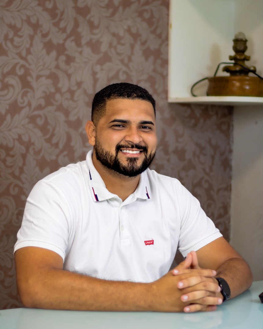 Jefferson Yuri Teixeira Lima sorrindo na mesa do consultório
